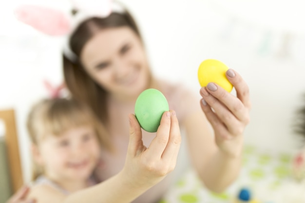 Mãe e filha defocused com ovos de aster