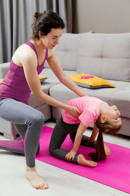 Mãe e filha fazendo esporte em casa