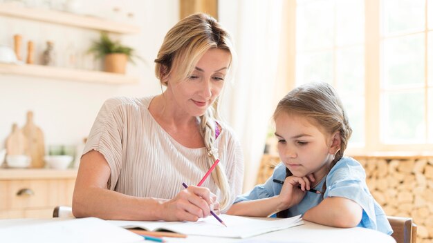 Mãe e filha fazendo lição de casa em casa