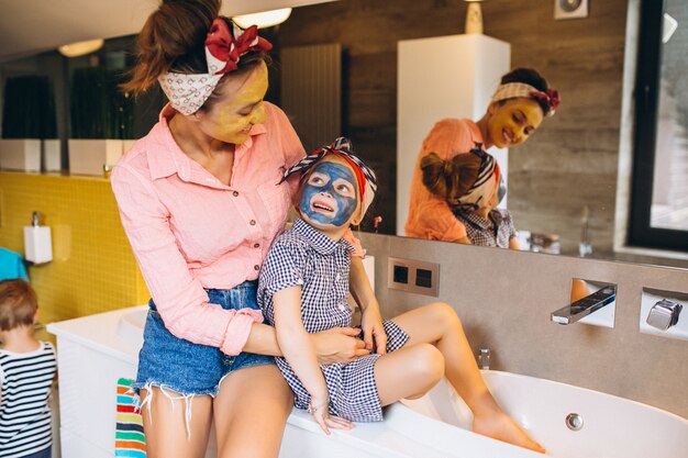 Mãe e filha fazendo máscaras em casa