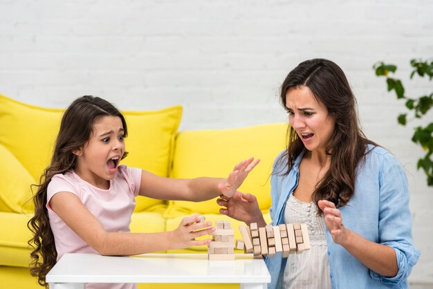 Mãe e filha jogando um jogo da torre de madeira