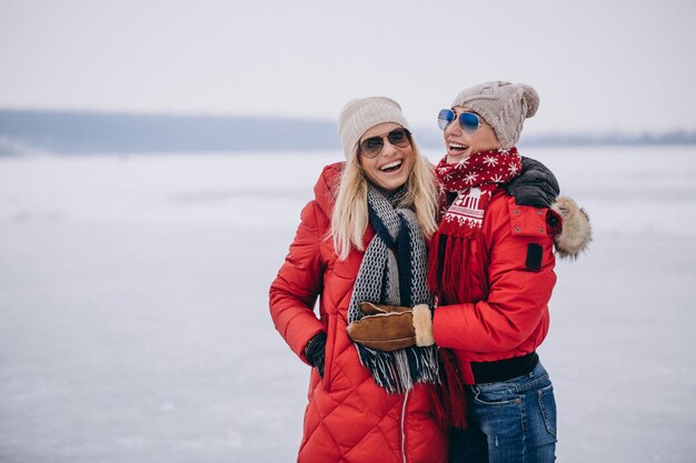 Mãe e filha juntos caminhando no parque no inverno