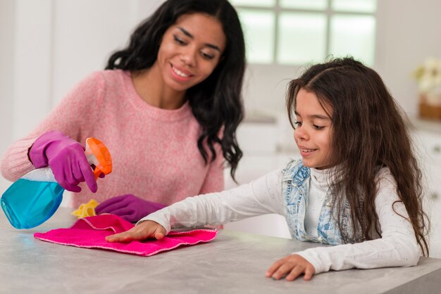 Mãe e filha, limpando a casa