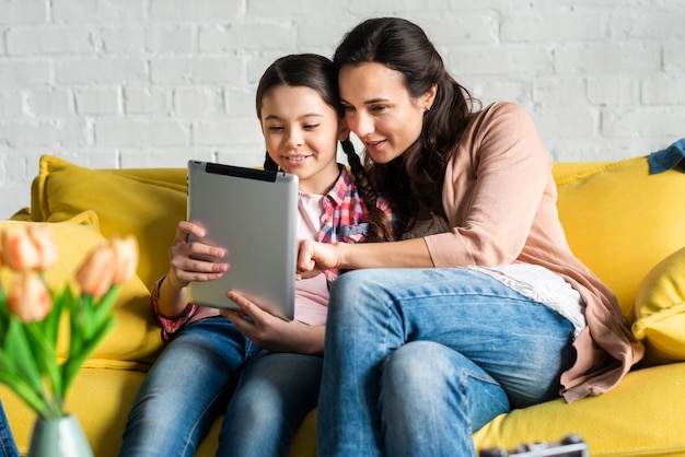 Mãe e filha olhando em um tablet digital