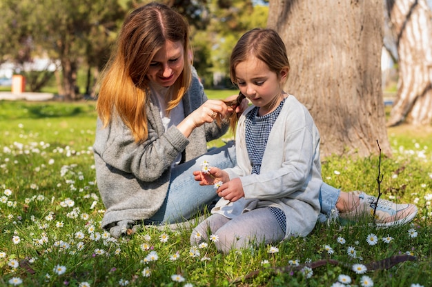 Mãe e filha olhando flores