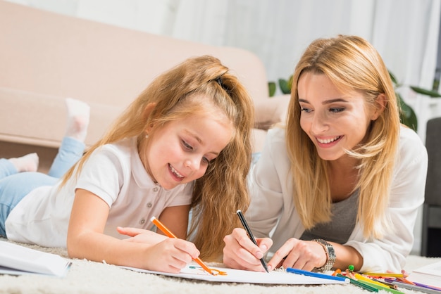 Mãe e filha pintando no chão