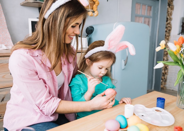 Mãe e filha pintando ovos para a Páscoa