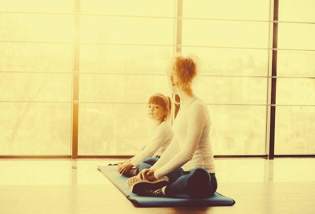 Mãe e filha praticando ioga