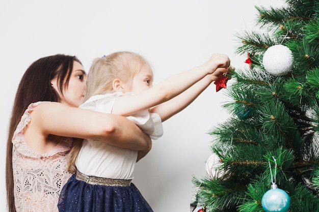 Mãe e filha que decoram a árvore de natal