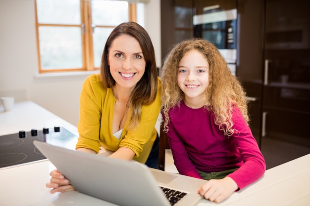 Mãe e filha que usa o portátil