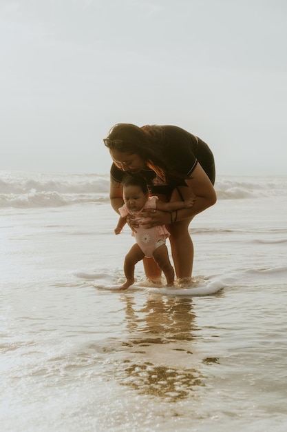 Mãe e filha recém-nascida na praia