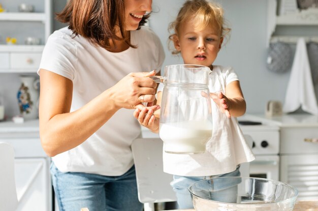 Mãe e filha segurando um copo de leite