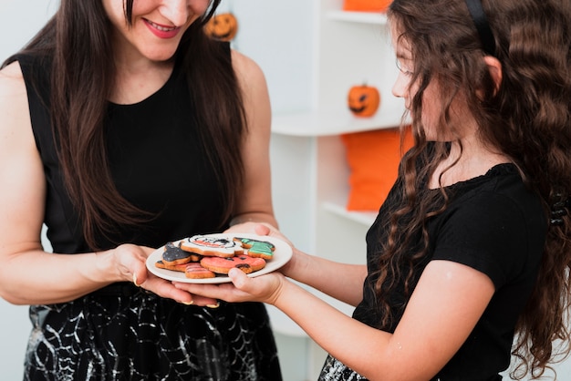 Foto grátis mãe e filha segurando um prato com biscoitos