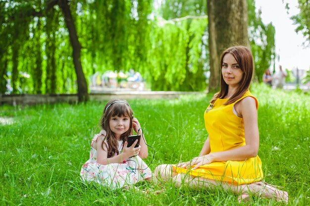 Mãe e filha sentada em um parque