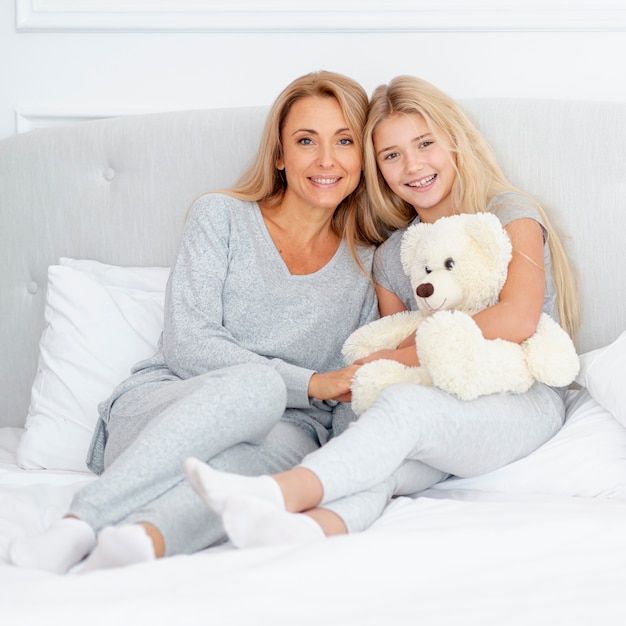 Mãe e filha sentada na cama