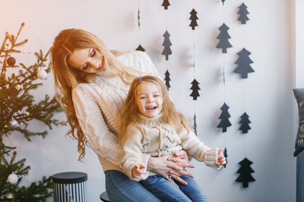 mãe e filha sentadas em decorações de férias