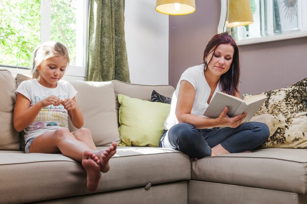 Mãe e filha sentadas no sofá relaxante