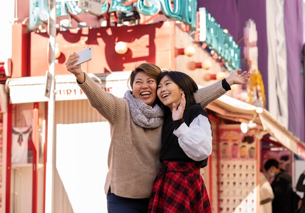 Mãe e filha tirando selfie em foto média