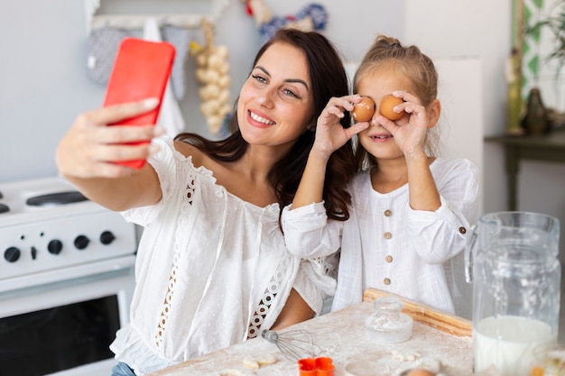 Mãe e filha tomando selfie com olhos de ovo