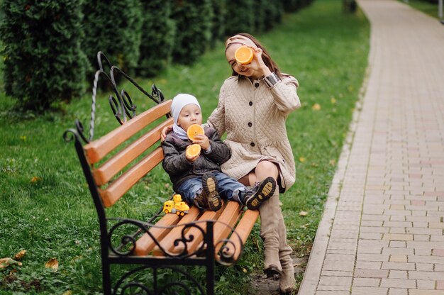 Mãe e filho caminhando e se divertindo juntos no parque outono.