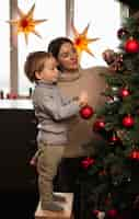 Foto grátis mãe e filho decorando a árvore de natal