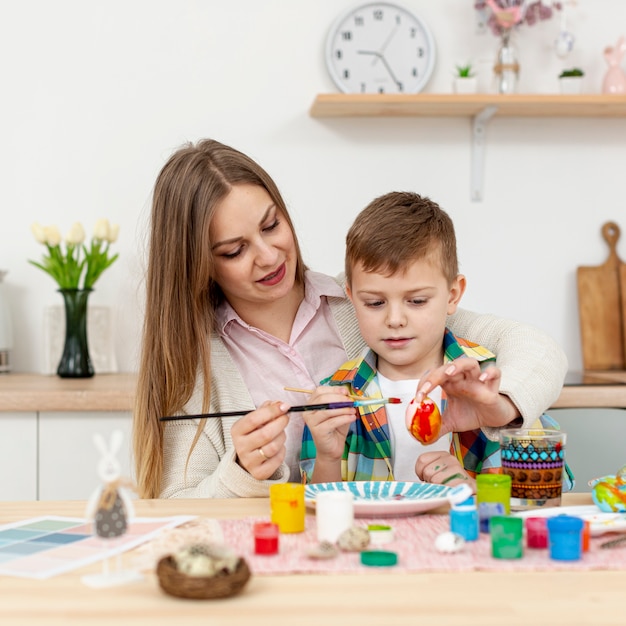 Mãe e filho juntos a pintar ovos de Páscoa