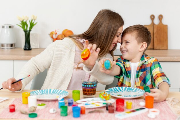 Mãe e filho mostrando seus ovos pintados