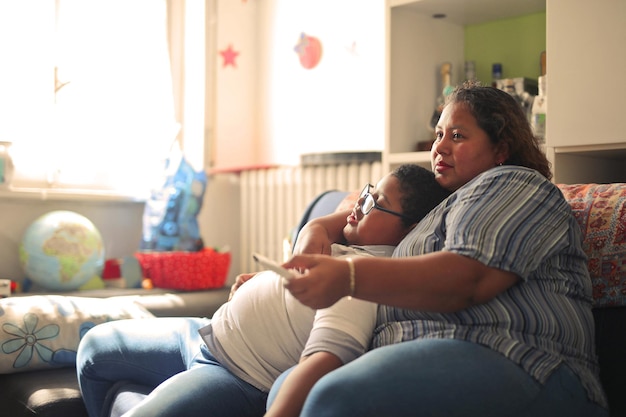 Foto grátis mãe e filho no sofá assistem televisão