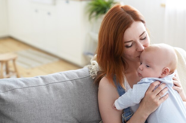 Mãe e filho posando em ambientes fechados