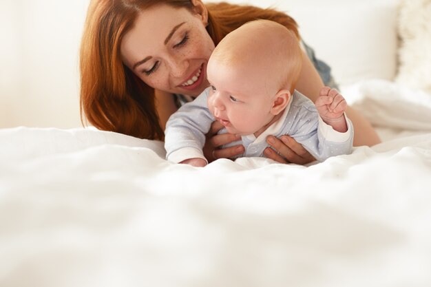 Mãe e filho posando em ambientes fechados