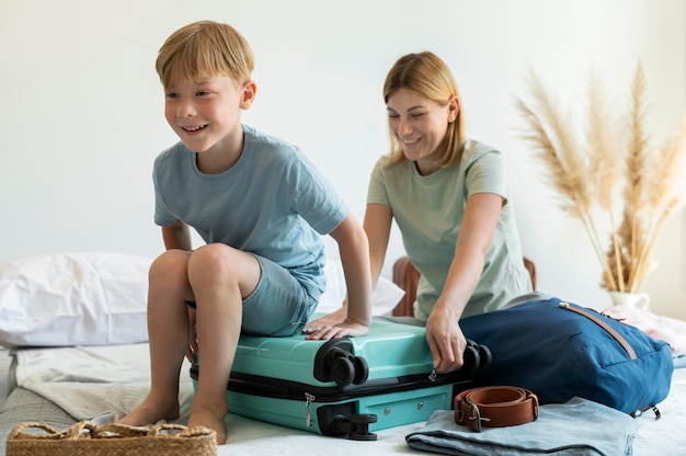 Mãe e filho preparando uma mala para as férias