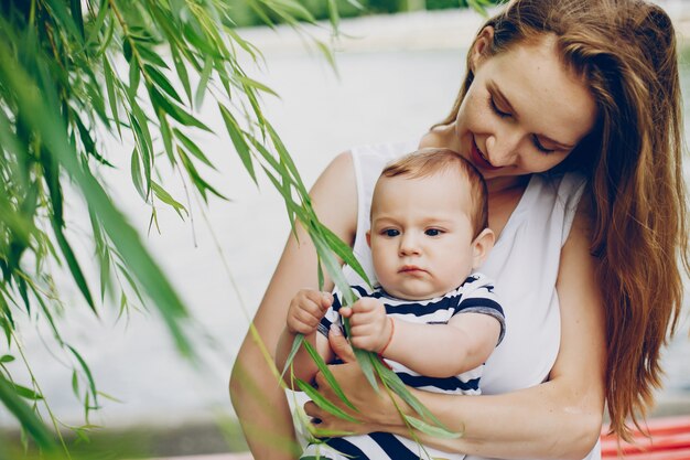 Mãe e filho relaxar no parque e caminhar ao redor do rio.