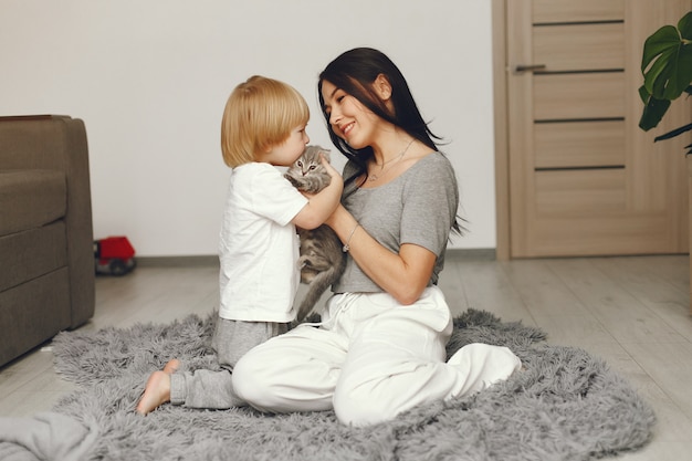 Mãe e filho se divertem em casa com um gato