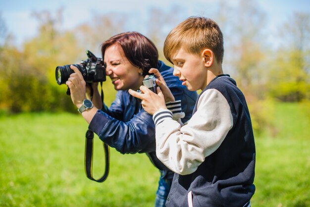 Mãe e filho tirando fotos ao ar livre