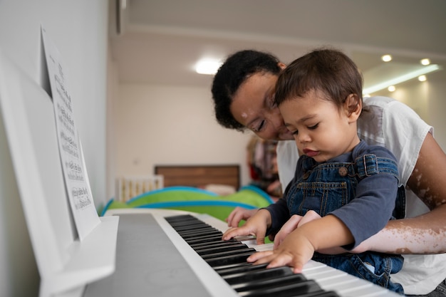 Foto grátis mãe e filho tocando piano