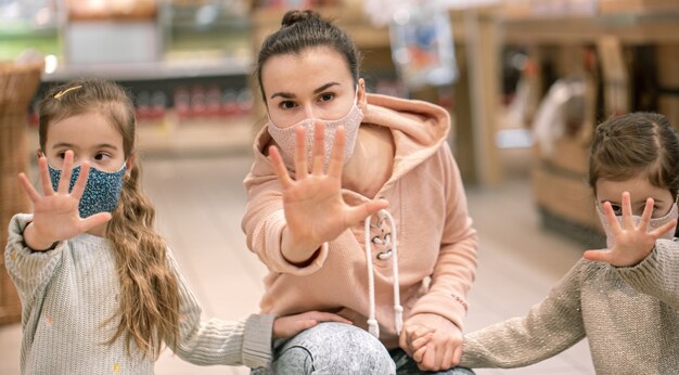 Mãe e filhos estão comprando no supermercado. Eles usam máscaras durante a quarentena. Coronavirus Pandemic .COVED-19 Flash. A epidemia do vírus