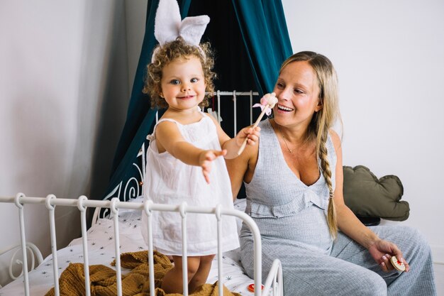 Mãe e garota alegre com orelhas de coelho