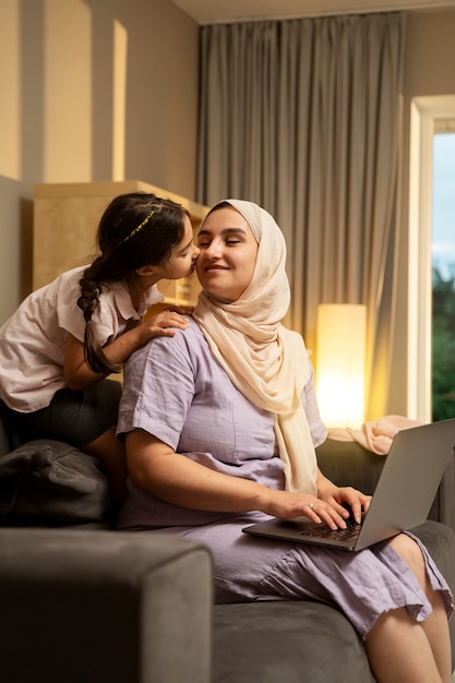 Foto grátis mãe e menina com vista lateral para laptop