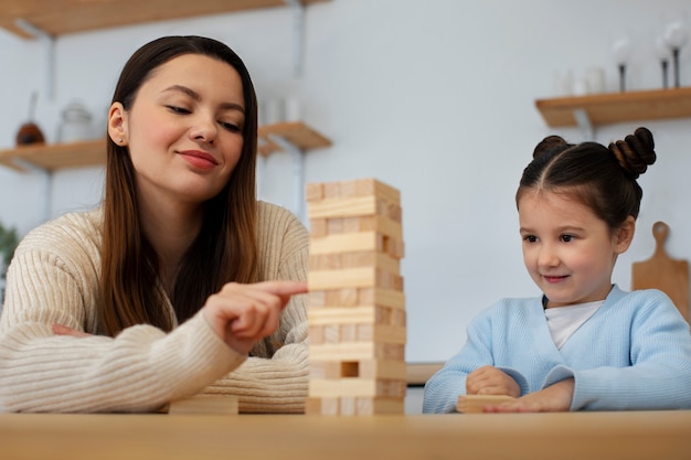 Foto grátis mãe e menina jogando vista frontal do jogo