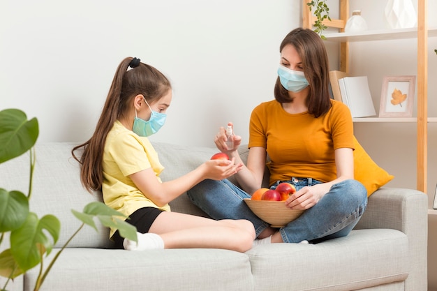 Mãe e menina no sofá com frutas