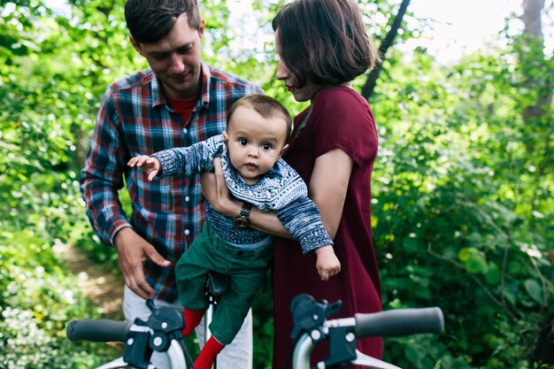 Mãe e pai colocando criança na bicicleta