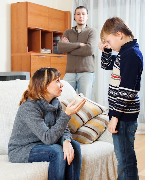 Mãe e pai que repreende o filho na sala de estar