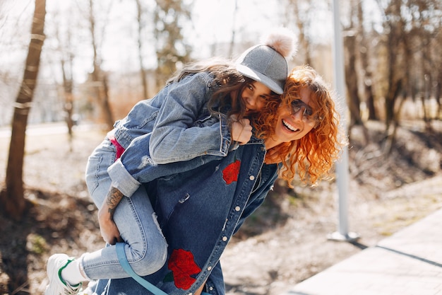 Mãe elegante com a filha em um parque de verão