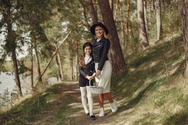 Foto grátis mãe elegante com filha em uma floresta de verão