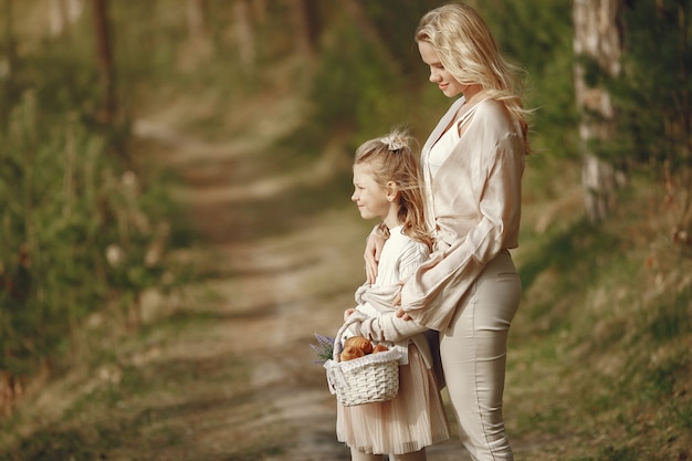 Mãe elegante com filha em uma floresta de verão