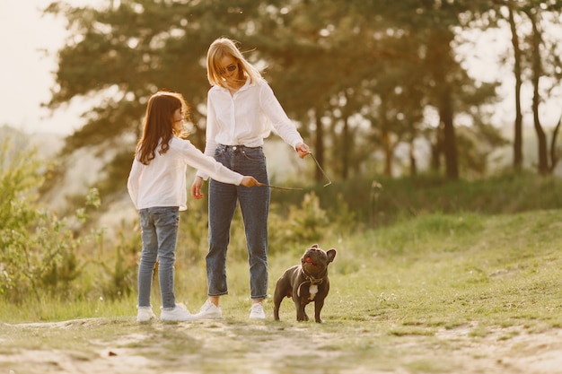 Mãe elegante com filha em uma floresta de verão