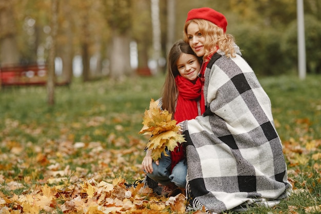 Mãe elegante com filha. Outono amarelo. Mulher com um lenço vermelho.