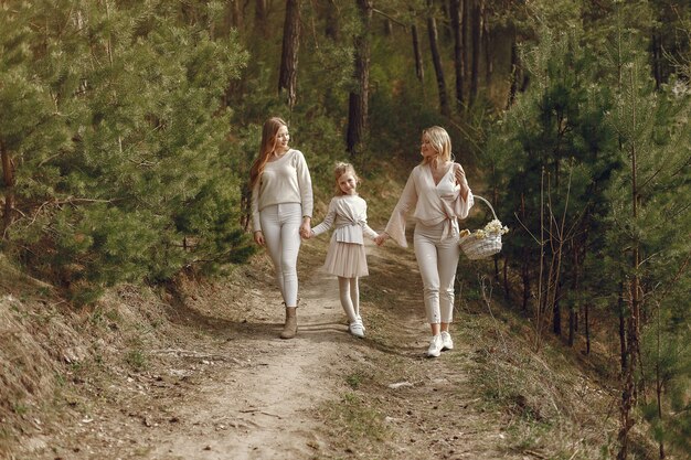 Mãe elegante com filhos em uma floresta de verão