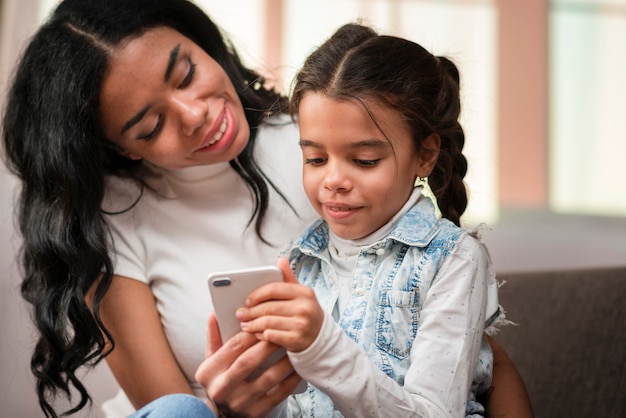 Mãe ensinando criança a usar o telefone