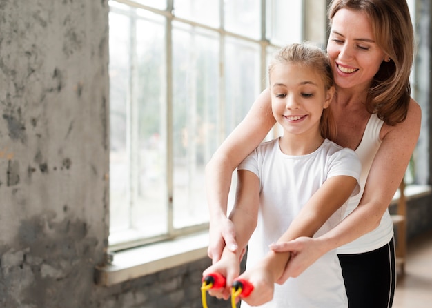 Foto grátis mãe ensinando filha a usar corda de pular